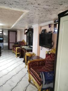 a living room with couches and a flat screen tv at راس البر المستشارين in ‘Izbat ash Sharāyid