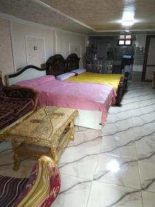 two beds in a room with tables and chairs at راس البر المستشارين in ‘Izbat ash Sharāyid