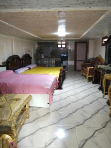 a room with two beds and chairs in it at راس البر المستشارين in ‘Izbat ash Sharāyid