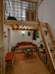 a living room with a loft bed and a couch at La Maison des Amis in Fez