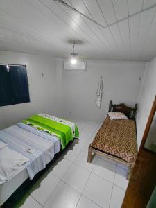a bedroom with two beds and a bench in it at SUÍTE Botos De Alter in Alter do Chao