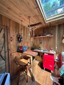 a kitchen with wooden walls and a table and a window at Cabana da Árvore e Cabana Retrô - ForestPlace in Monte Verde
