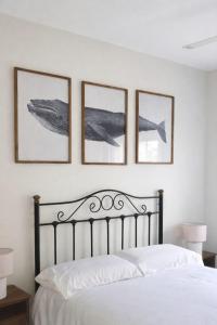 a bedroom with a bed with four pictures on the wall at La Alcazaba de Cristina in El Puerto de Santa María +37 photos