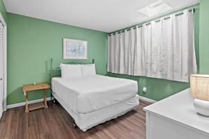 a bedroom with a bed and a green wall at Emerald Breeze in Destin +35 photos