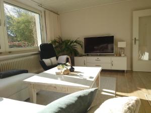 a living room with a couch and a tv at Ferien am See in Möhnesee
