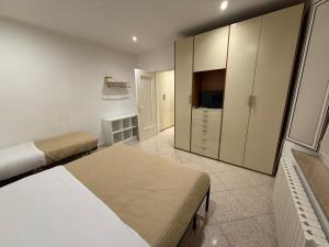 a bedroom with two beds and a tv and cabinets at Sotto il Borgo Apartments in Iesi +13 photos