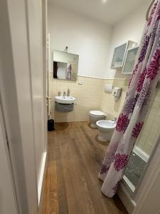a bathroom with a toilet and a shower curtain at Sotto il Borgo Apartments in Iesi