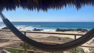 eine Hängematte auf einem Balkon mit Blick auf das Meer in der Unterkunft UtopiAmar Beach House & Suites in Playa Agua Blanca