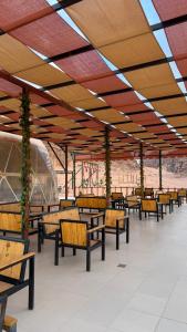 a row of benches in a building with a roof at Hkaya Rum camp in Disah