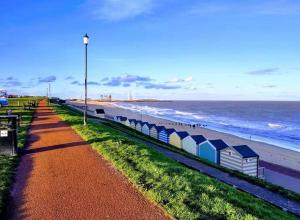 a row of beach huts next to the ocean at Silver stays, calm coastal stay , close to beach in Gorleston-on-Sea