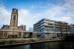 a building and a church with a clock tower at Motel One Rotterdam in Rotterdam