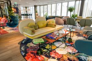 a living room with a couch and a rug at Motel One Rotterdam in Rotterdam +34 photos