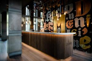 a bar with a wooden counter in a room at Motel One Hannover-Oper in Hannover