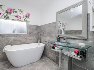 a bathroom with a tub and a sink and a mirror at Hazelodge in Coniston +48 photos