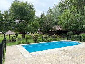 a blue swimming pool in front of a yard at Cabañas La Cautiva in Tanti
