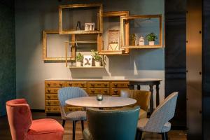 a room with a table and chairs and mirrors at Motel One Hannover-Oper in Hannover +38 photos