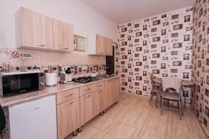 a kitchen with wooden cabinets and a wall with photographs at Apartament Andreas - centru, confort si relaxare in Arad