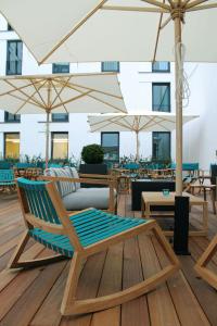 a patio with a chair and umbrellas and tables at Motel One Bremen-Altstadt in Bremen