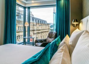 a bedroom with a view of the city from a window at Motel One Manchester-Royal Exchange in Manchester +29 photos