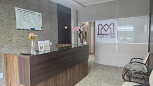 a lobby with a reception desk with flowers on it at Mendes Residence in Belém