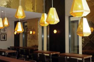a restaurant with wooden tables and chairs and lights at Motel One Leipzig-Augustusplatz in Leipzig +32 photos