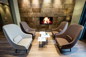 a waiting room with chairs and a fireplace at Motel One Magdeburg in Magdeburg