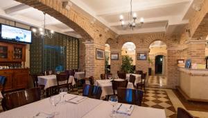 een restaurant met tafels en stoelen en een bakstenen muur bij Hotel Azimut in Sveti Stefan