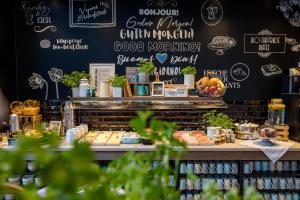 a bakery with a black wall with signs on it at Motel One Rostock in Rostock