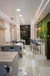 a restaurant with tables and chairs and a green wall at Hostal Valle Andino in El Tambo