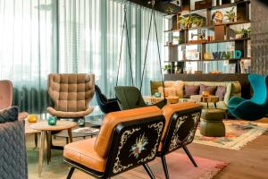 a living room filled with chairs and tables at Motel One Salzburg-Süd in Salzburg +28 photos