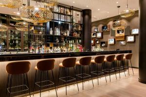 a bar with brown stools in a room at Motel One Köln-Messe in Cologne