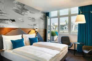 a hotel room with a bed and a window at Motel One Zürich in Zurich +56 photos