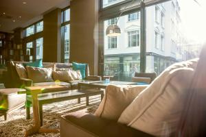 a lobby with couches and tables in a building at Motel One Leipzig-Augustusplatz in Leipzig