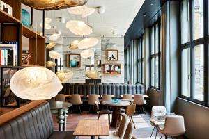 a restaurant with tables and chairs and windows at Motel One Zürich in Zurich