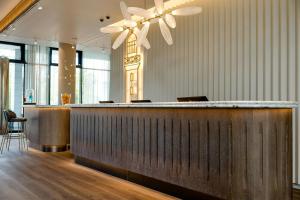 a bar in a restaurant with a ceiling fan at Motel One Rostock in Rostock +22 photos