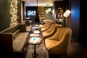 a row of couches in a room with a table at Motel One Newcastle in Newcastle upon Tyne