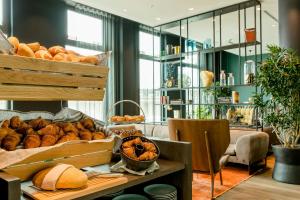 a room with a table with lots of loaves of bread at Motel One Köln-Messe in Cologne