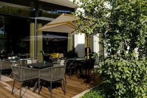 a patio with tables and chairs and an umbrella at Motel One Köln-Altstadt in Cologne