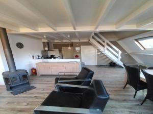 a living room with black chairs and a stove at Chalet in Tyrol near Ski Slope in Stramproy