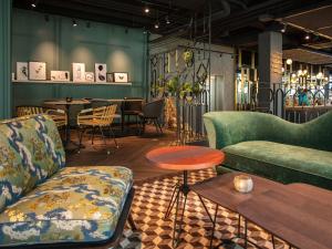 a room with two couches and a table and chairs at Motel One Saarbrücken in Saarbrücken