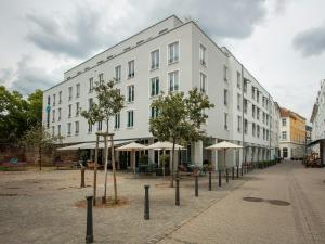 a white building with trees in front of it at Motel One Saarbrücken in Saarbrücken