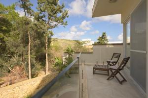 a balcony with two chairs and a bench on a house at Villa Marni in Xlendi