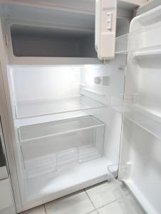 ein leerer Kühlschrank mit offener Tür in der Unterkunft MonAppart in Gera