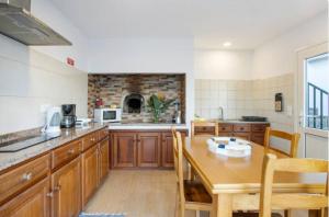 a kitchen with wooden cabinets and a wooden table at Casa dos avós in São Vicente