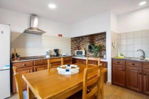 a kitchen with a wooden table and wooden cabinets at Casa dos avós in São Vicente