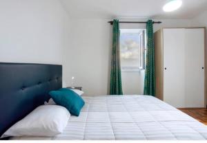 a bedroom with a large bed with blue and white pillows at Casa dos avós in São Vicente