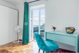 a blue desk and a chair in a room with a window at Casa dos avós in São Vicente
