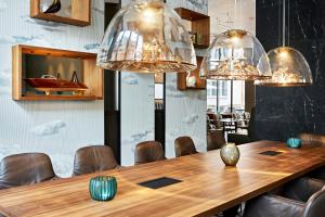 a dining room with a wooden table and chandeliers at Motel One Zürich in Zurich