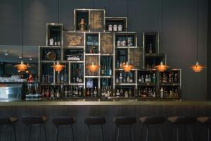 a bar with four stools in front of it at Motel One Lübeck in Lübeck