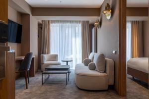 a hotel room with a couch and a bed at MontiSio Boutique Hotel in Gudauri